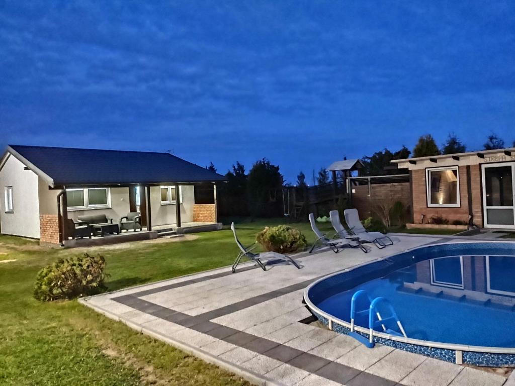 a backyard with a swimming pool and a house at Domek parterowy apartamentowy Ostoja in Rewal