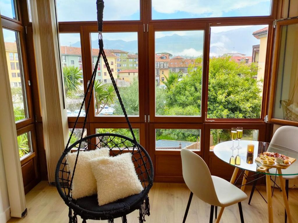 a swing in front of a window with a table at Salitre en el Cuera in Llanes