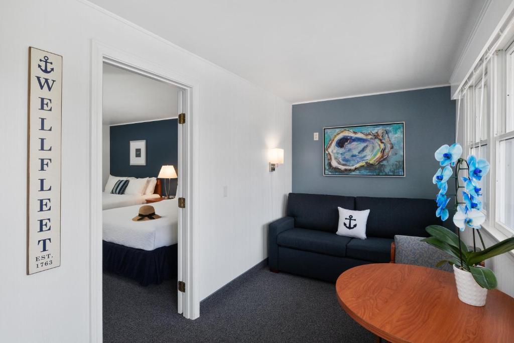 um quarto com uma cama, um sofá e uma mesa em Even'tide Resort Motel & Cottages em Wellfleet