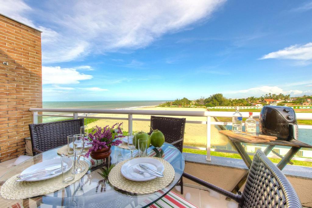 balcón con mesa, sillas y vistas al océano en Breezes Do Cumbuco #404 - Na Praia por carpediem, en Cumbuco