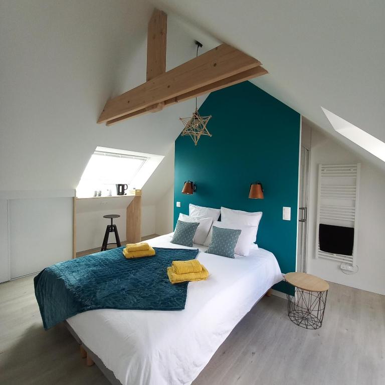 une chambre avec un grand lit avec un mur bleu dans l'établissement Chambre d'hôtel tout confort au Pays des Abers, à Plouguerneau