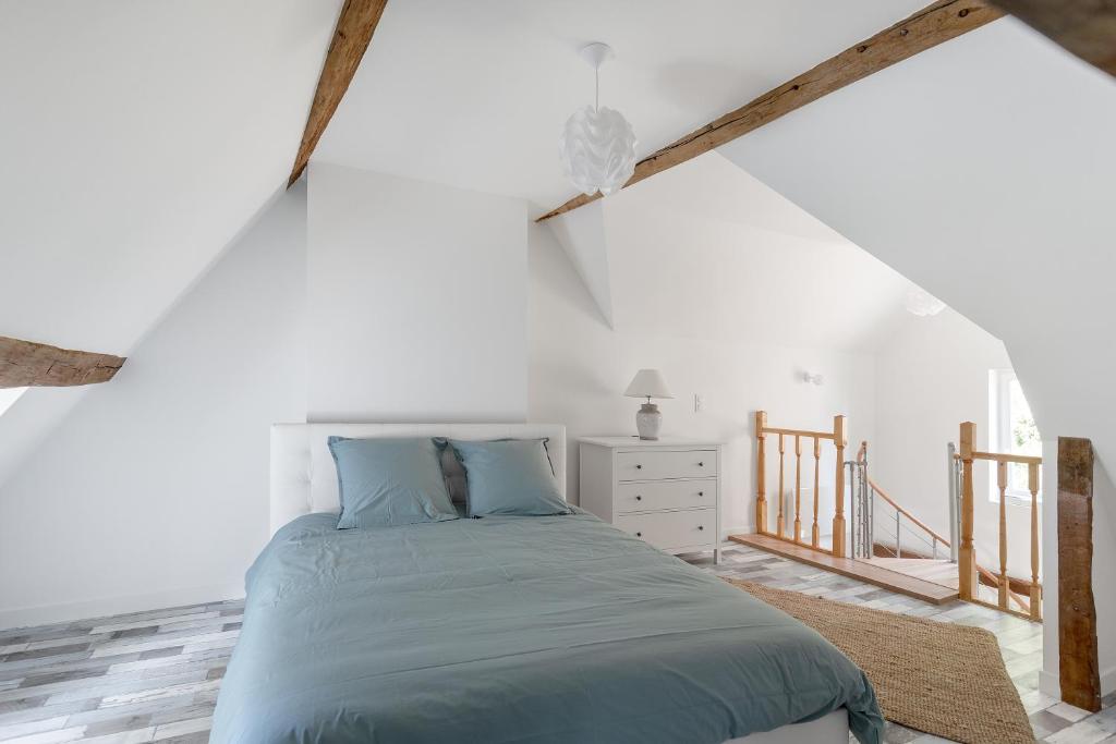 ein Schlafzimmer mit einem Bett in einem weißen Zimmer in der Unterkunft Un petit coin de Cathédrale in Beauvais