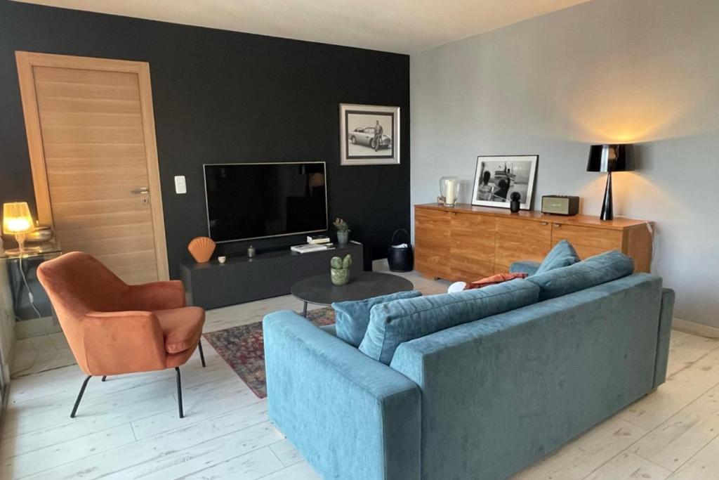 un salon avec un canapé bleu et une chaise dans l'établissement Deux pièces spacieux Place de Gaulle centre-ville d'Antibes avec extérieur, à Antibes
