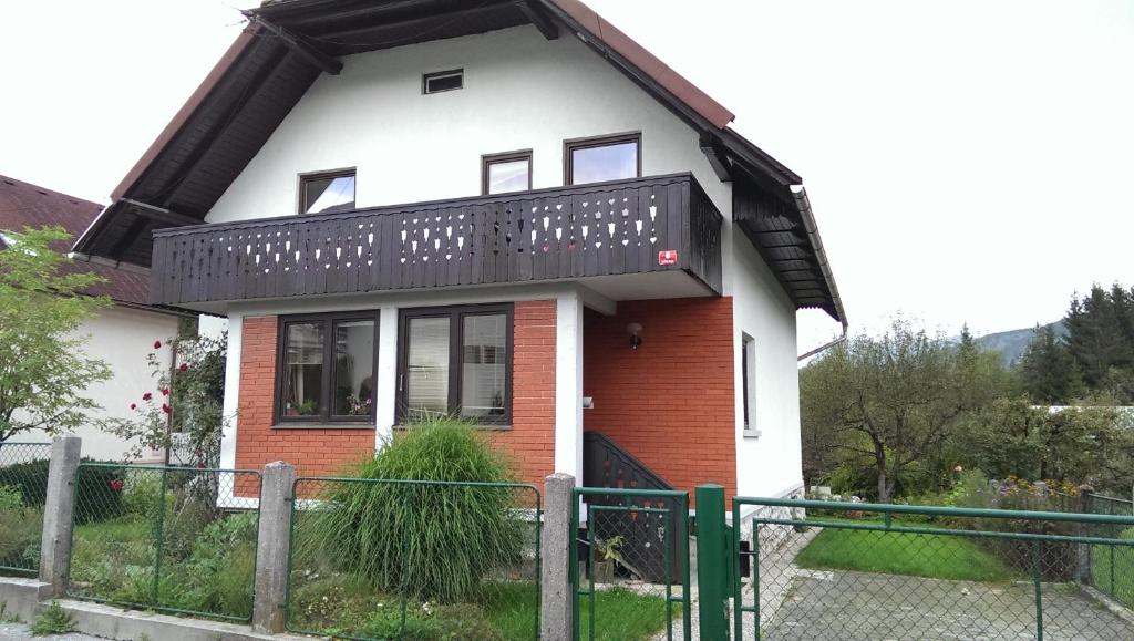 a white and red house with a black balcony at Room Sodja in Bohinj