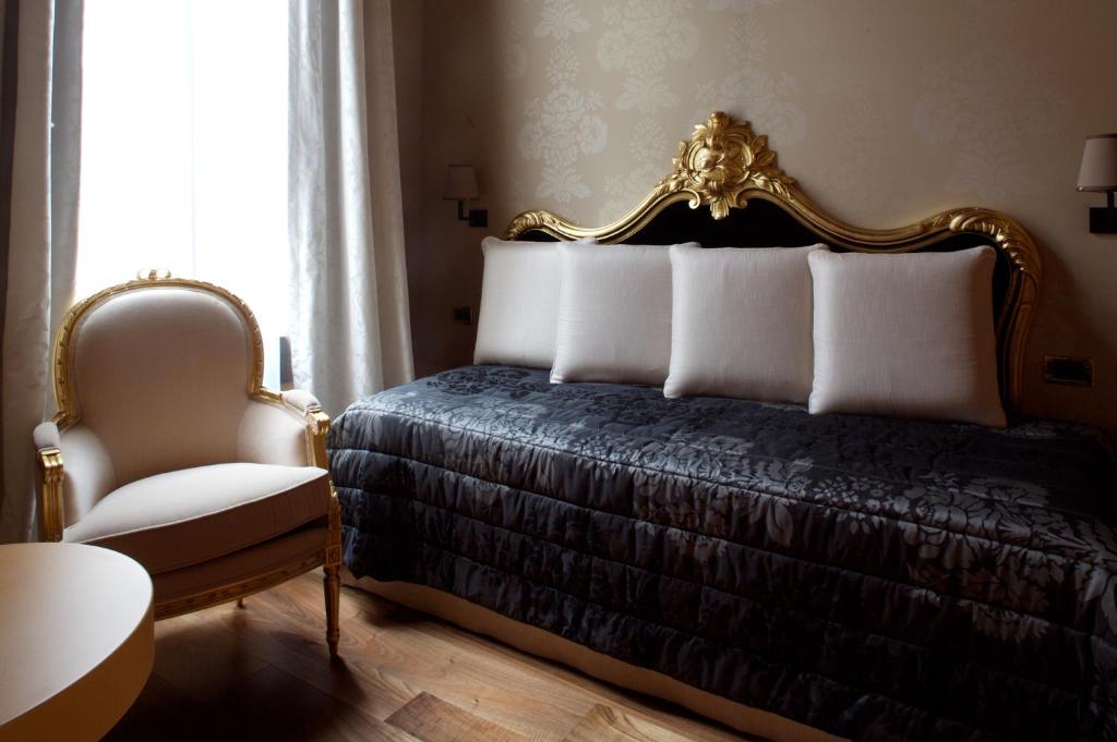 sypialnia z łóżkiem i krzesłem w obiekcie Hotel Ca' Zusto Venezia w Wenecji