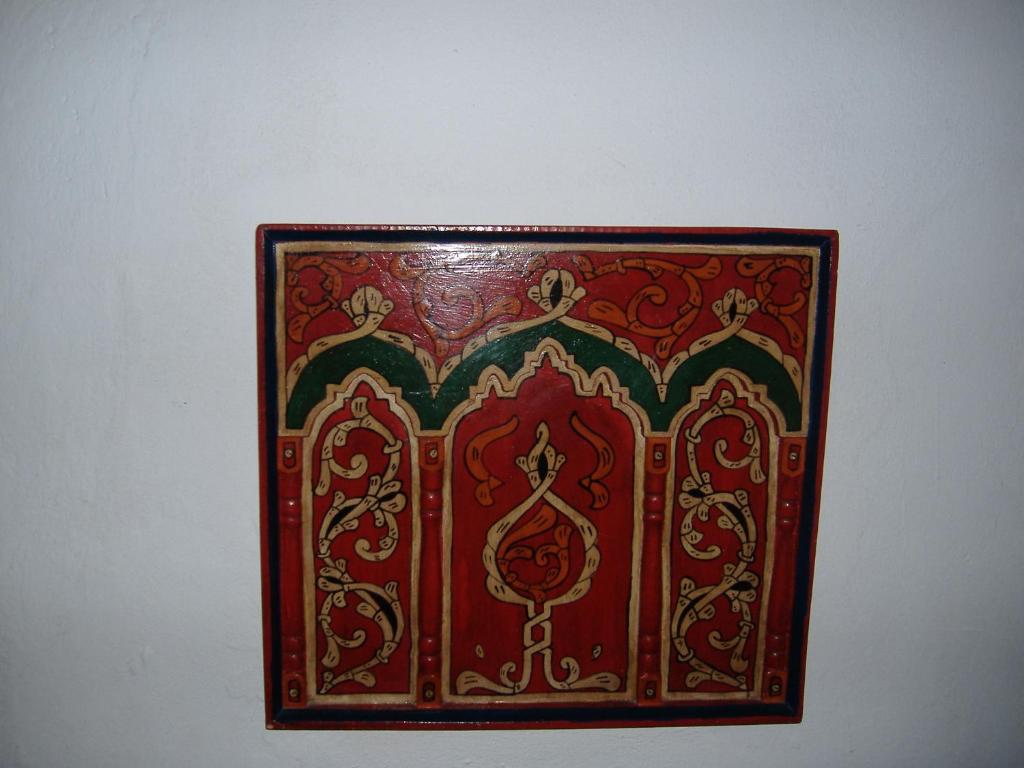 a red picture frame hanging on a wall at Casa La Palma in Chefchaouene