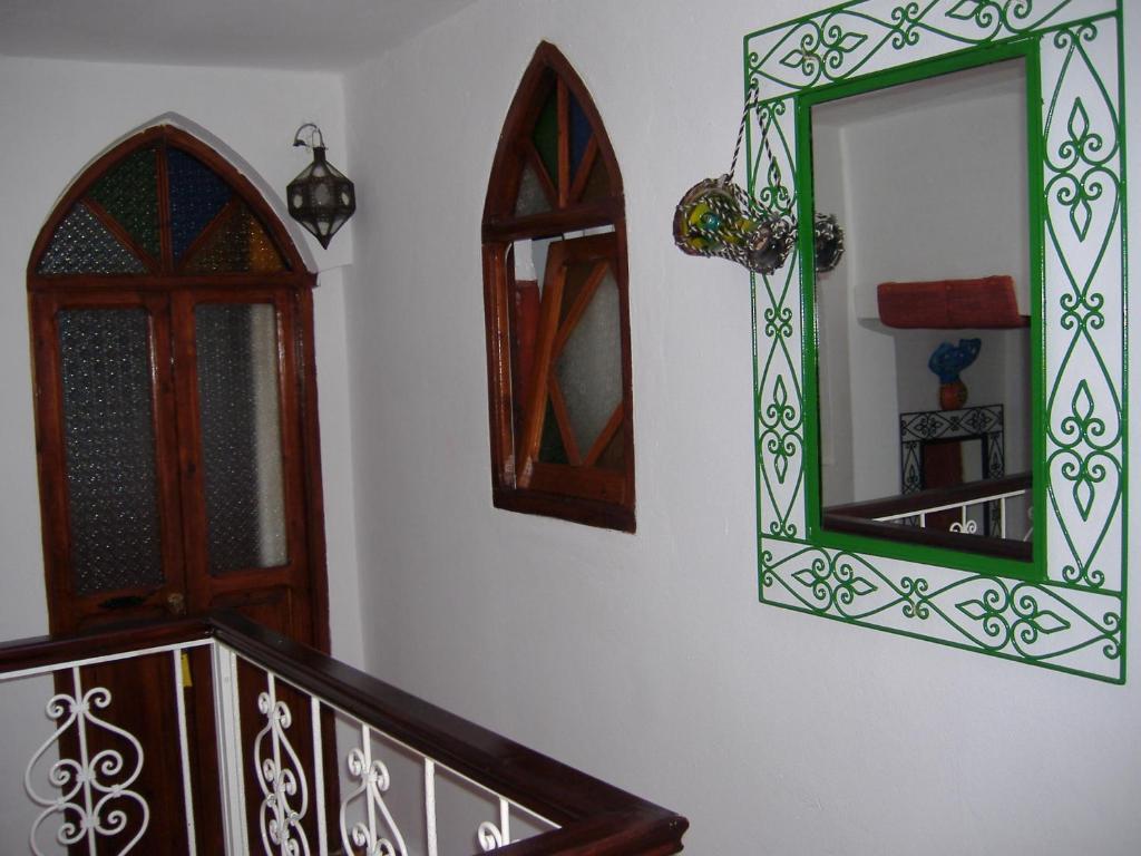 a mirror on a wall next to a staircase at Casa La Palma in Chefchaouene