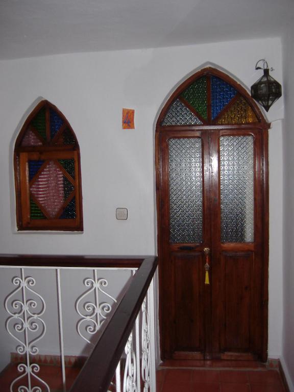 a staircase with a wooden door and a window at Casa La Palma in Chefchaouene