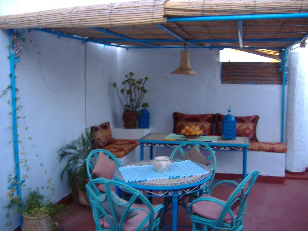 a patio with a table and chairs in a room at Casa La Palma in Chefchaouene