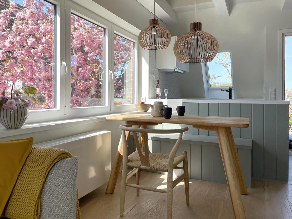 eine Küche mit einem Holztisch und 2 Fenstern in der Unterkunft Ferienwohnung Henny in Wyk auf Föhr