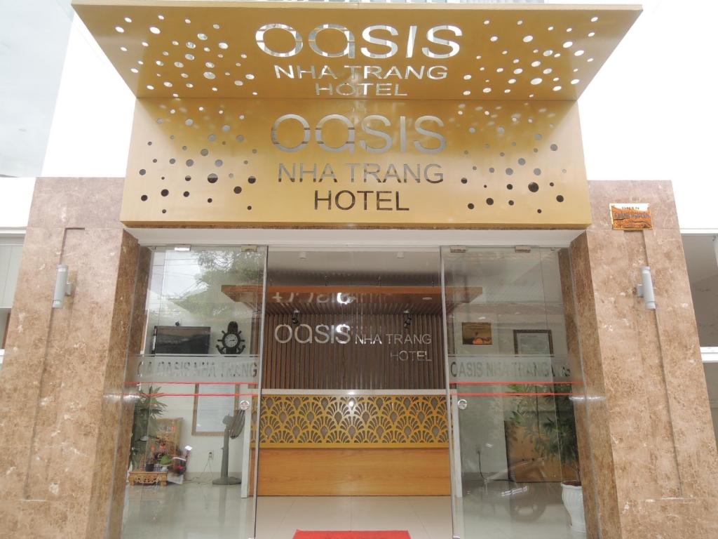 um edifício com uma placa que lê oasisma tang hotel em Oasis Nha Trang Hotel em Nha Trang