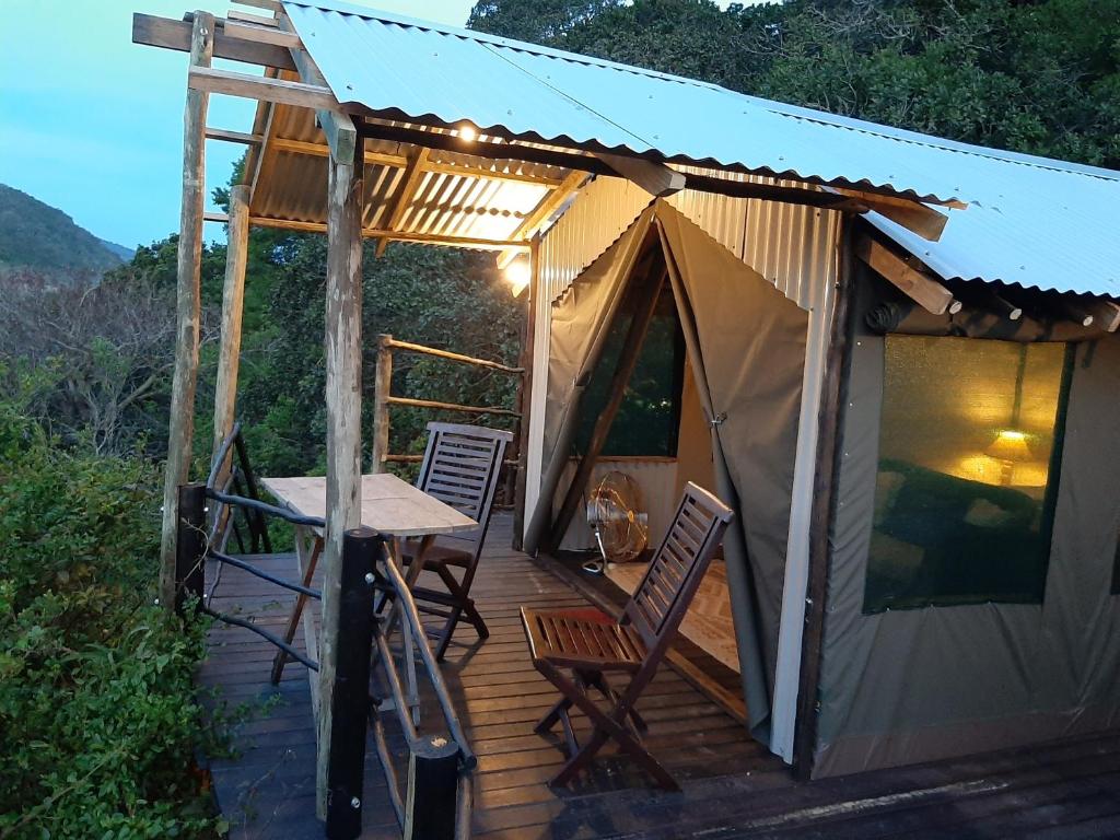 Zelt mit Stühlen und einem Tisch auf einer Terrasse in der Unterkunft The Nest @ The Old Trading Post in Wilderness