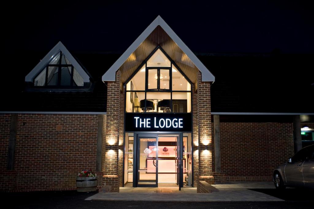 a building with a sign that reads the lodge at The Lodge at Kingswood in Epsom