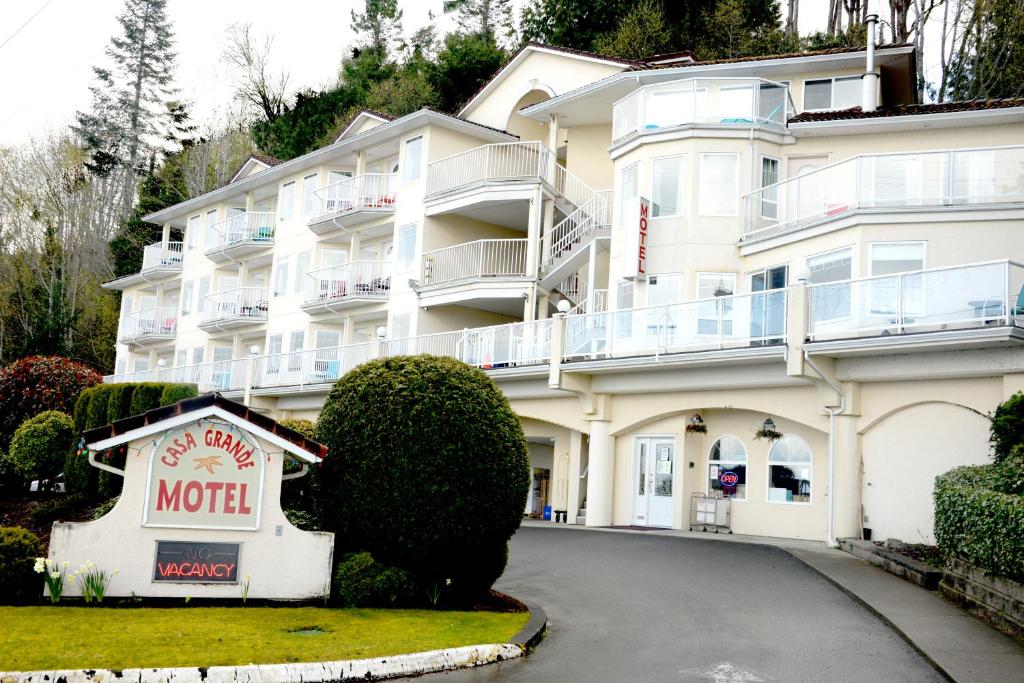 un hotel con un cartel de motel delante en Casa Grande Inn en Qualicum Beach