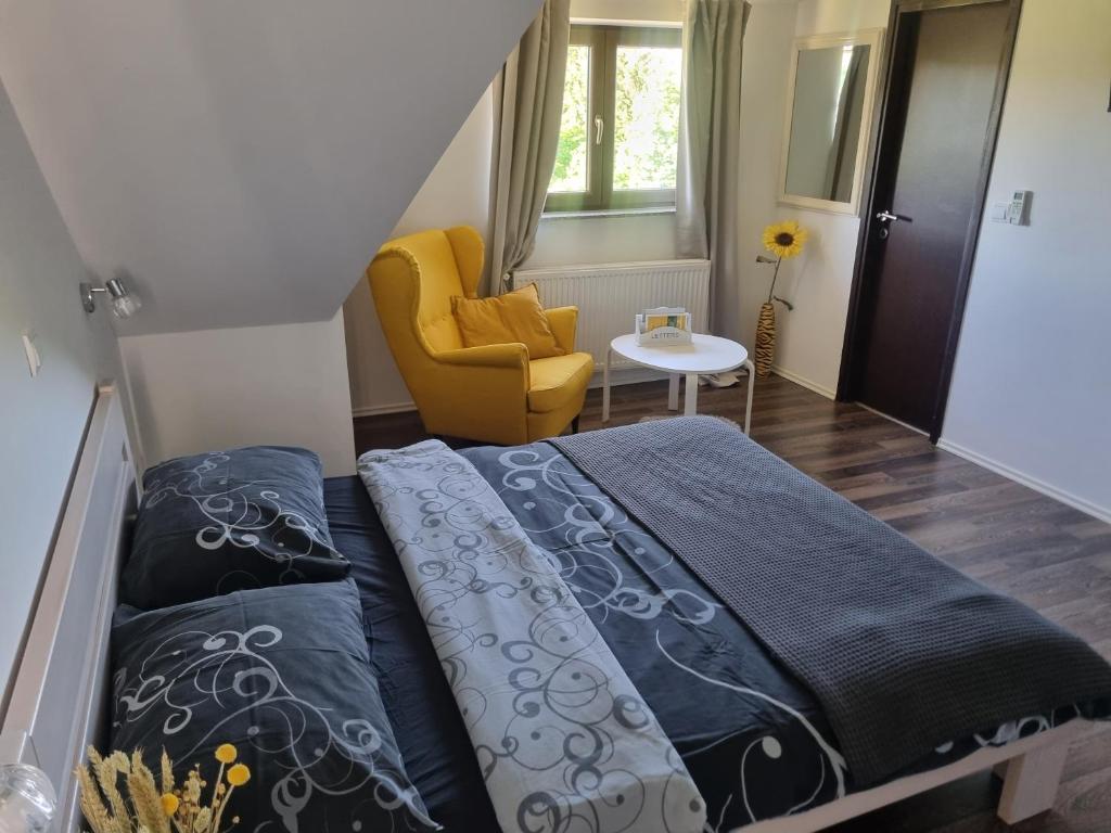 ein Schlafzimmer mit einem Bett und einem gelben Stuhl in der Unterkunft 4 Seasons Guest House in Rakovica