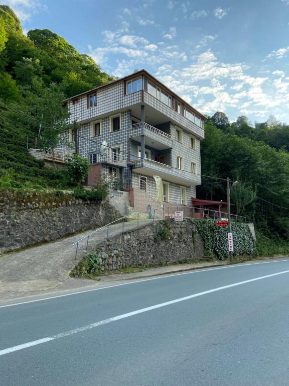 un bâtiment situé sur le côté d'une colline à côté d'une route dans l'établissement Lombane Apart, à Rize