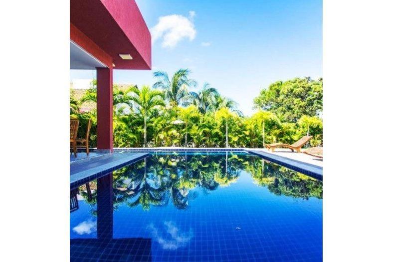una piscina frente a una villa en Casa Temporada - 4 suítes - Condomínio Luxo - Piscina Extraordinária - Praia de Itacimirim-BA en Camaçari