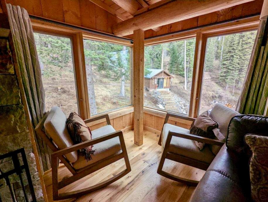 a living room with two chairs and a large window at Jackson Hole Hideout in Wilson