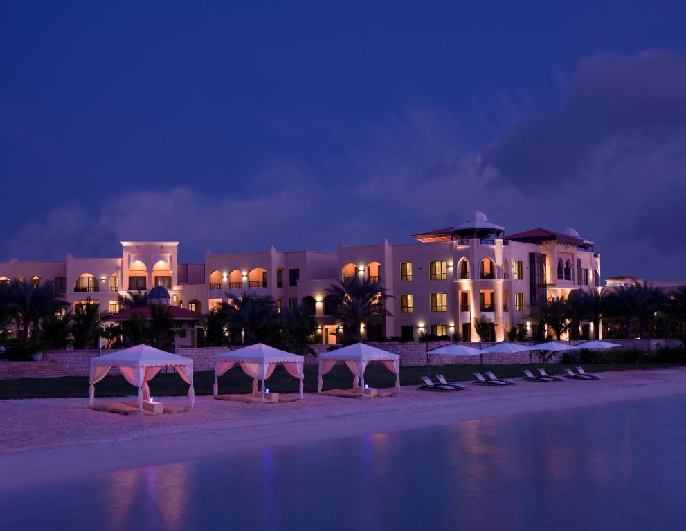 a group of umbrellas on the beach in front of a hotel at Traders Hotel, Abu Dhabi in Abu Dhabi