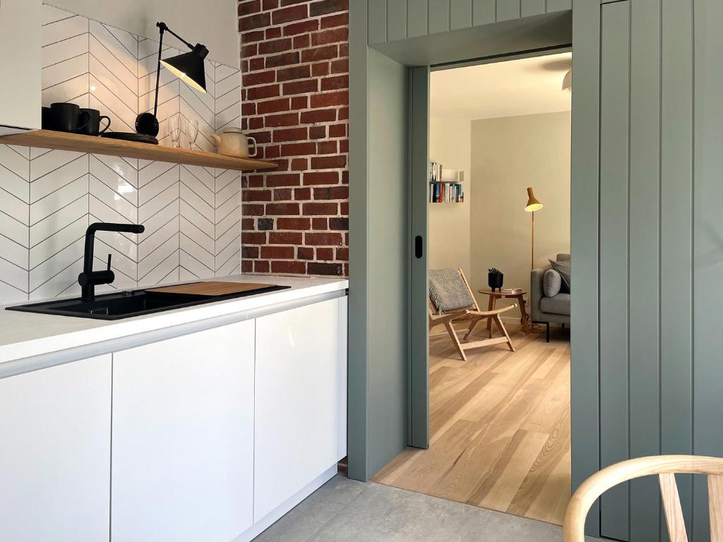 a kitchen with a sink and a brick wall at Ferienwohnung Klaus in Wyk auf Föhr