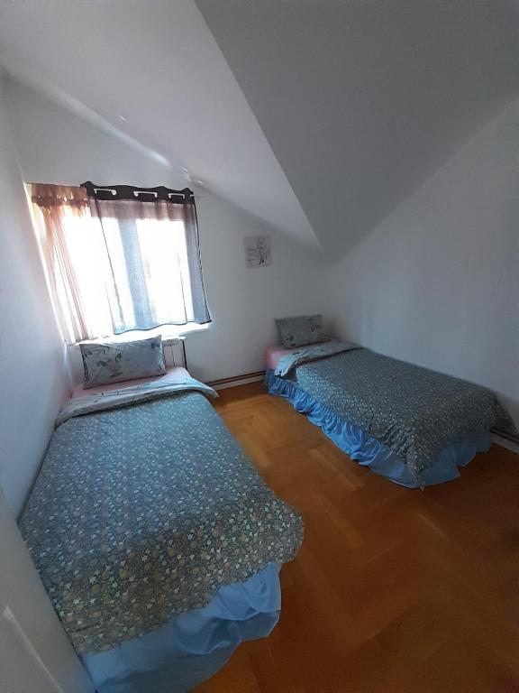 an attic room with two beds and a window at Apartment Ken in Surčin