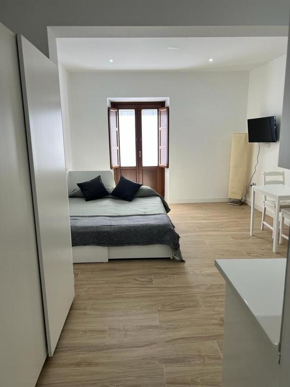 sypialnia z łóżkiem z oknem i stołem w obiekcie CASTRO Suites Osuna w mieście Osuna