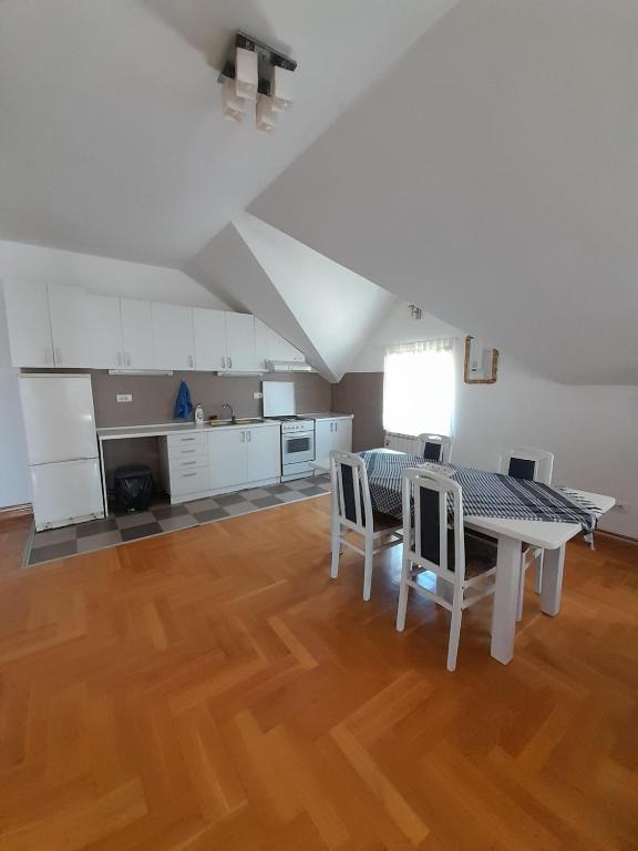 a kitchen and dining room with a table and chairs at Apartment Ken in Surčin