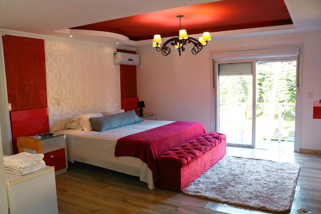 Un dormitorio con una cama grande y una lámpara de araña. en Amber 449 en Gramado