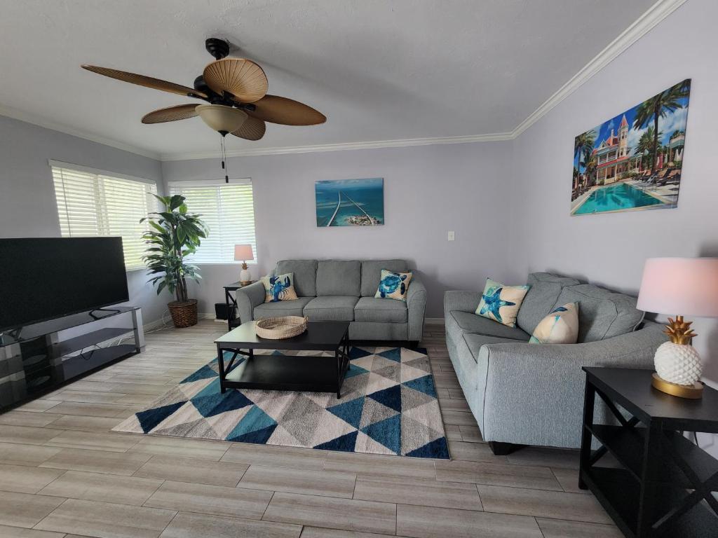 a living room with a couch and a ceiling fan at Old Town Suites in Key West