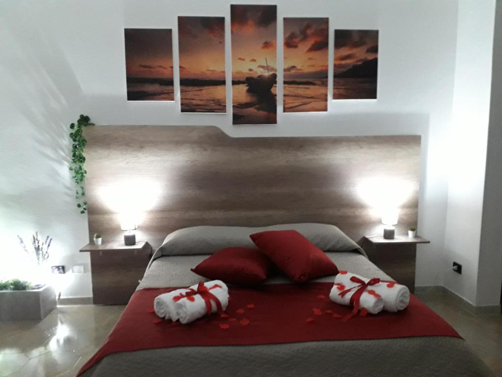 una camera da letto con un letto con cuscini rossi e bianchi di SHORT LETS Radici di Puglia a Fragagnano