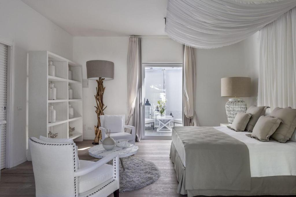 イスキアにあるRelais Corte Degli Aragonesiの白いベッドルーム(ベッド1台、椅子付)