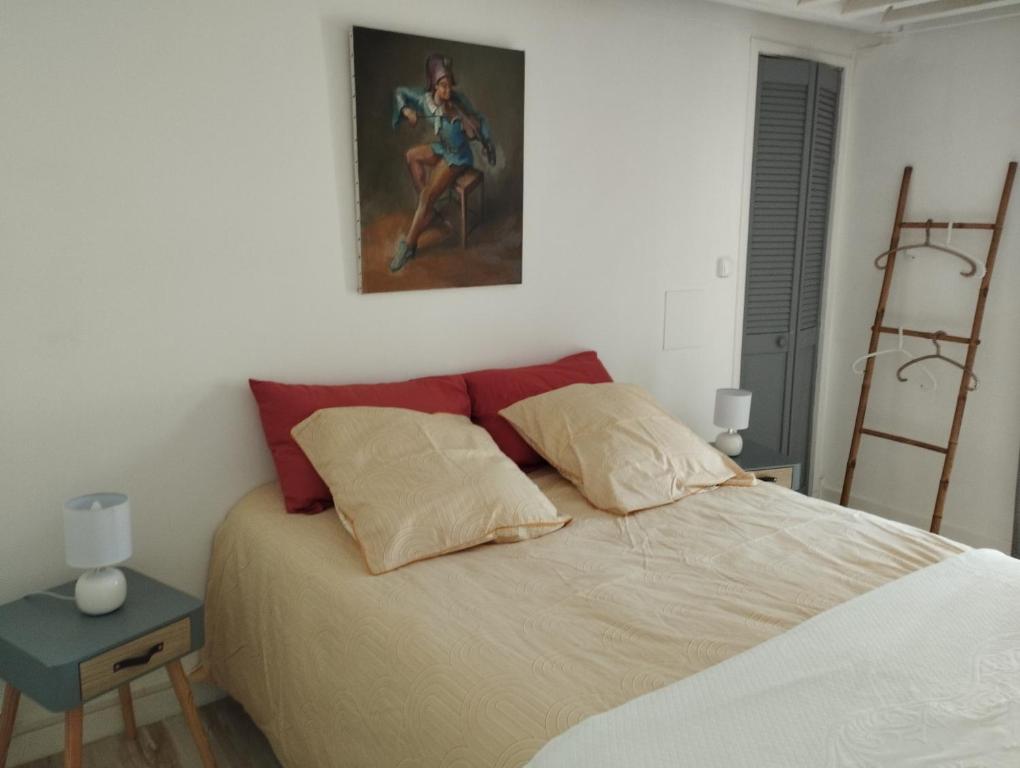 a bedroom with a bed and a painting on the wall at Maison du martin pêcheur à Lannion in Lannion