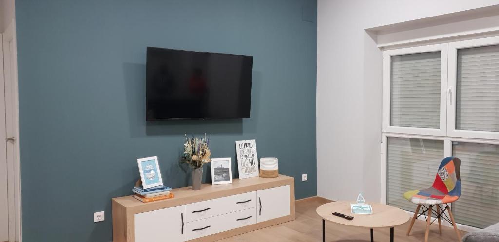 ein Wohnzimmer mit einem TV an einer blauen Wand in der Unterkunft A Solaina in Lariño