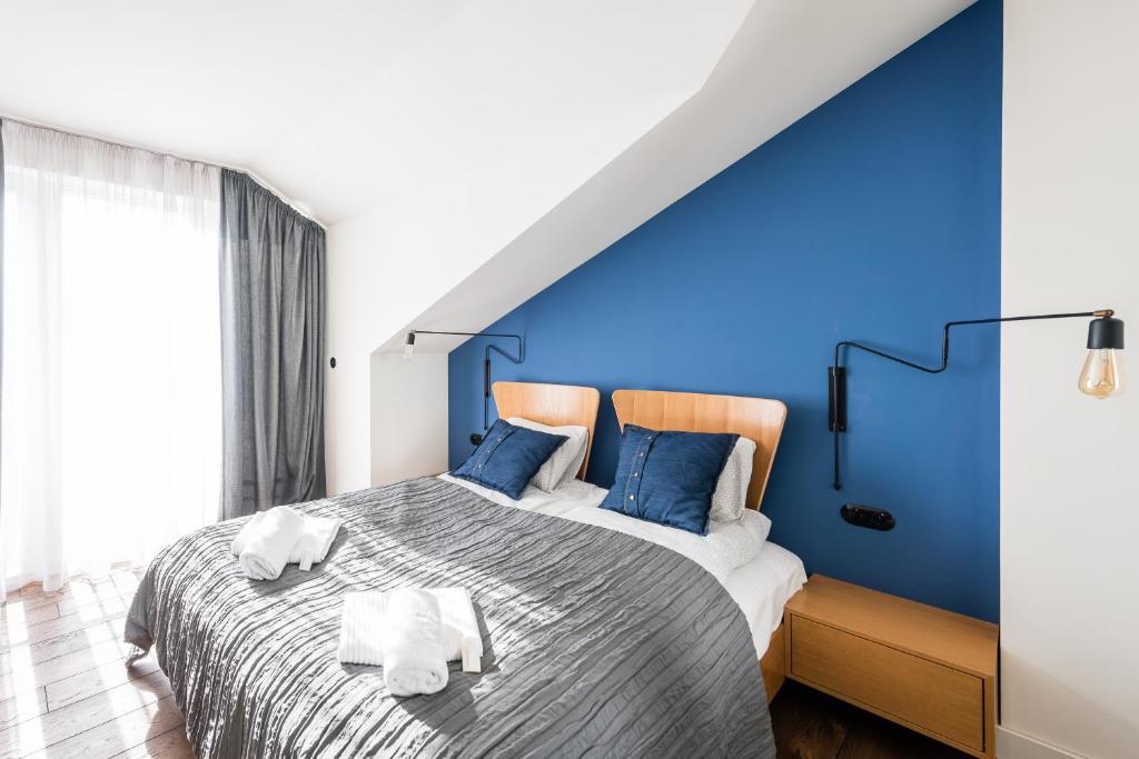 克拉科夫的住宿－Wegierska Luxury Loft WAWELOFTS，蓝色卧室设有一张带蓝色墙壁的大床