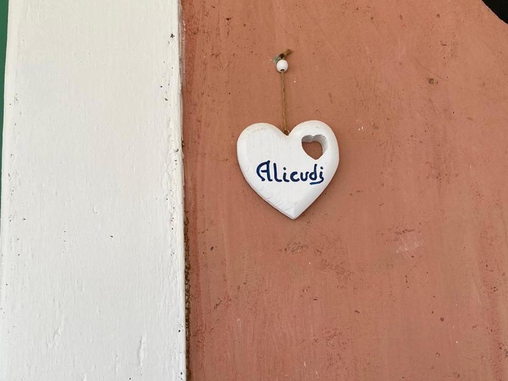 a heart shaped sign hanging on a door at Le Sette Sorelle in Filicudi