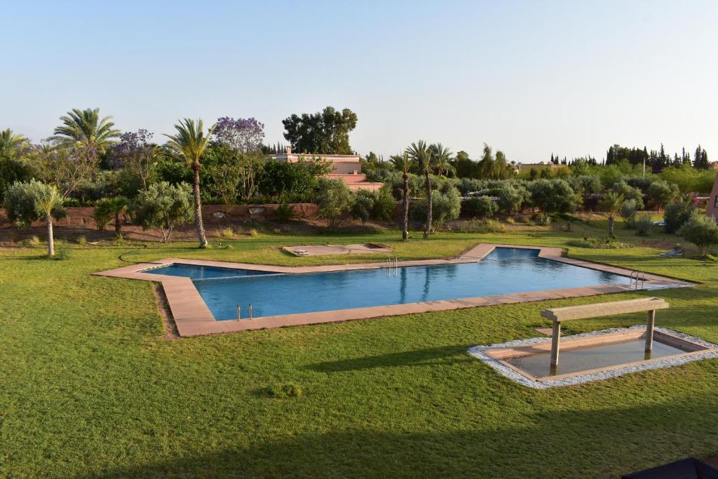 einen Blick über einen Pool in einem Park in der Unterkunft Villa Marrakech in Marrakesch