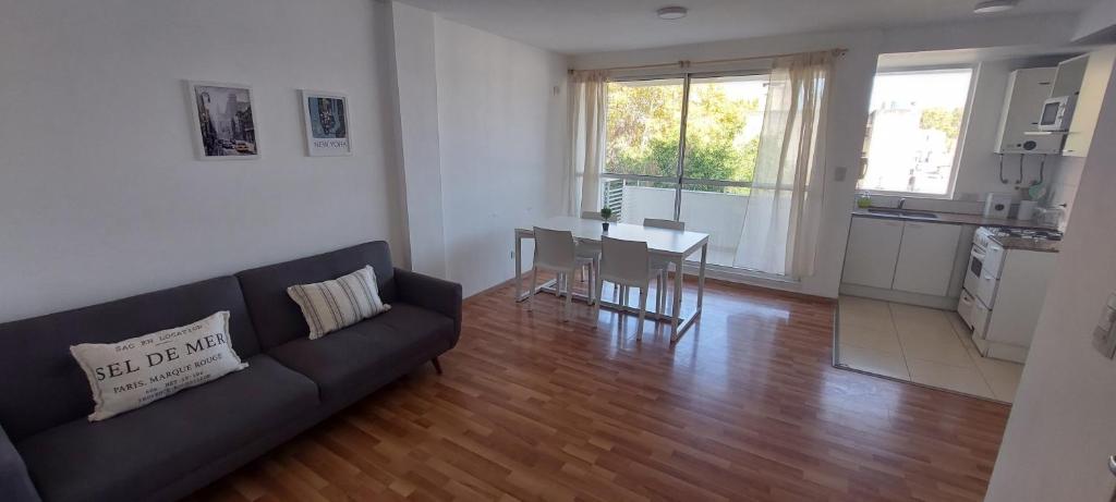 a living room with a couch and a table and a kitchen at A Metros del Parana - Facultad de Medicina in Rosario