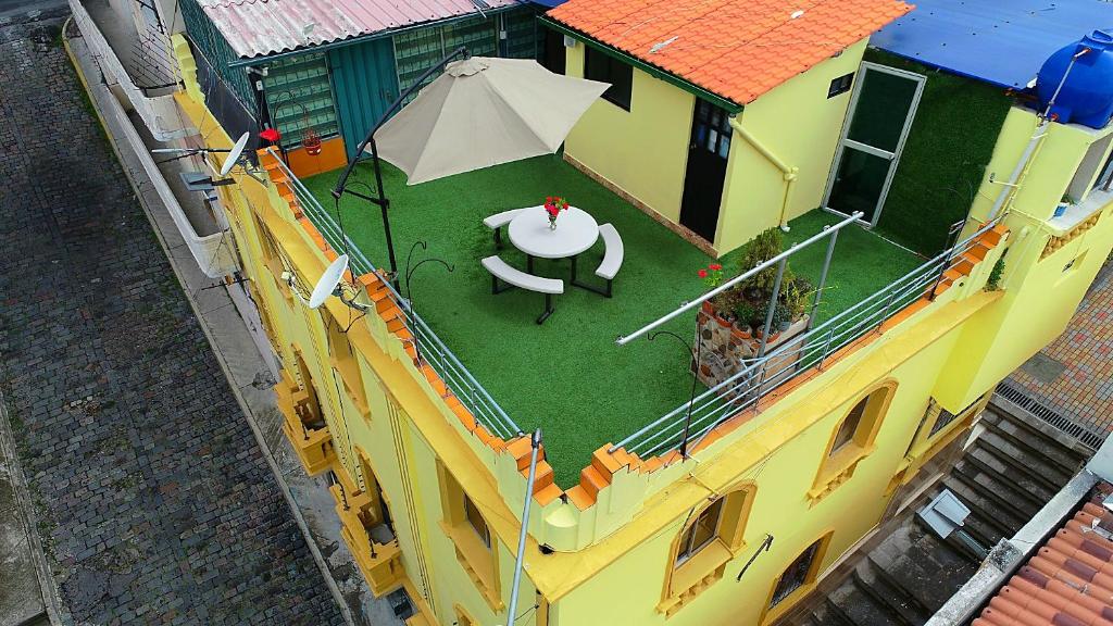 une vue de tête d'un bâtiment avec une table et un parasol dans l'établissement Olympus Plaza, à Quito