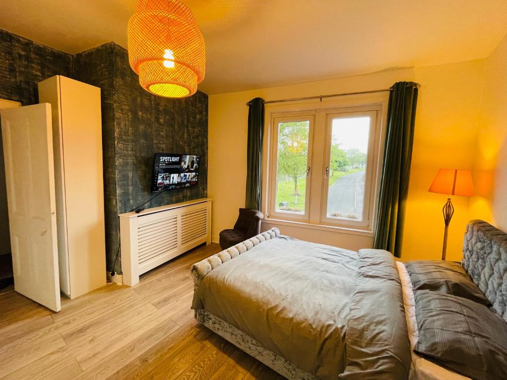 een slaapkamer met een bed en een raam bij Holiday Flat for All in Fife