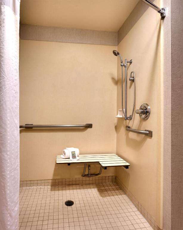 a bathroom with a shower and a bench in it at Best Western Downtown Phoenix in Phoenix