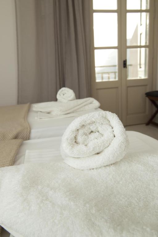 a stack of white towels sitting on a bed at Horizon Hotel Kalymnos in Myrties