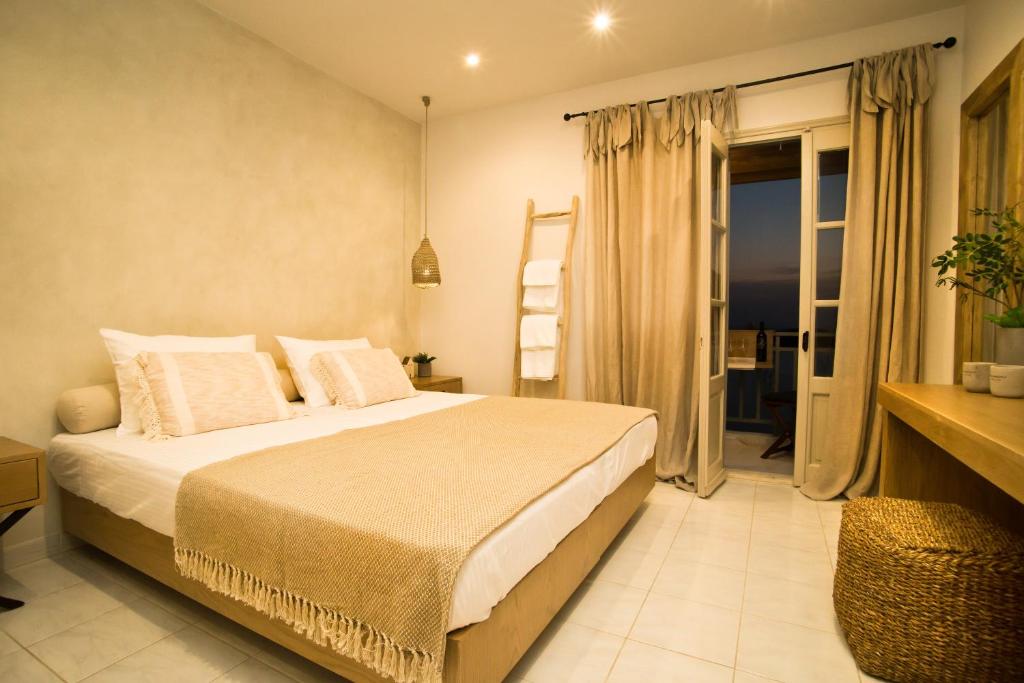 a bedroom with a large bed and a balcony at Horizon Hotel Kalymnos in Myrties