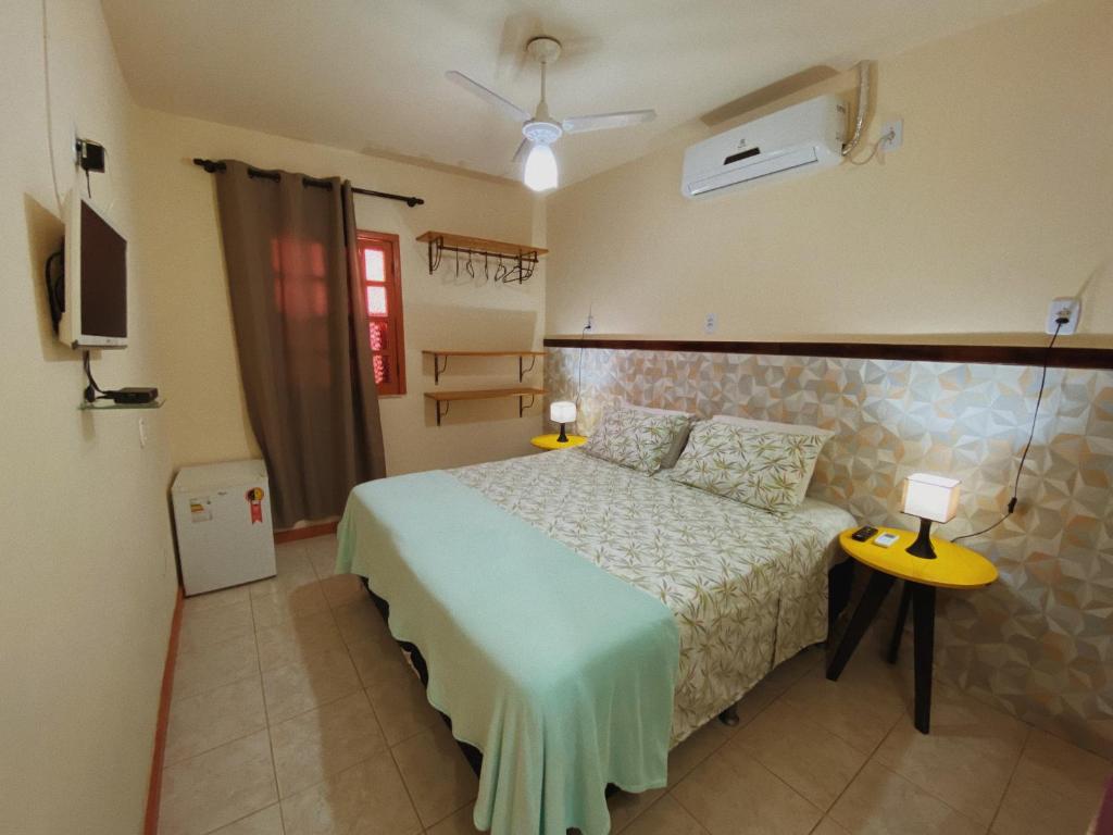 a bedroom with a bed and two lamps and a tv at Pousada da Villa in Lençóis
