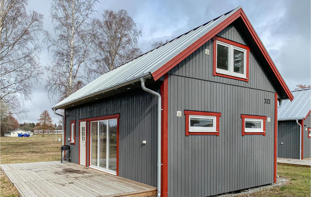 um edifício cinza e vermelho com um deque de madeira em Gorgeous Home In Lttorp With Wifi em Löttorp