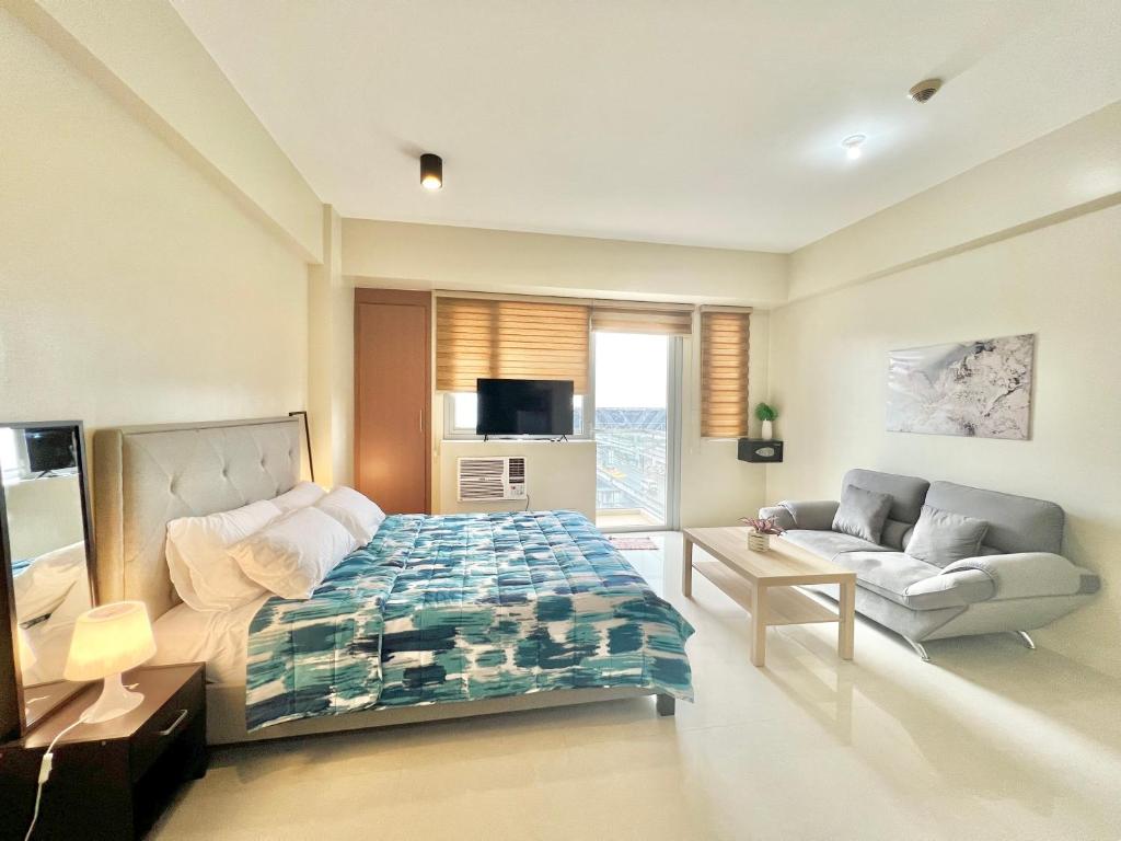 a bedroom with a bed and a couch in it at Luxury Hotel Type Condo Near NAIA Manila Airport in Manila