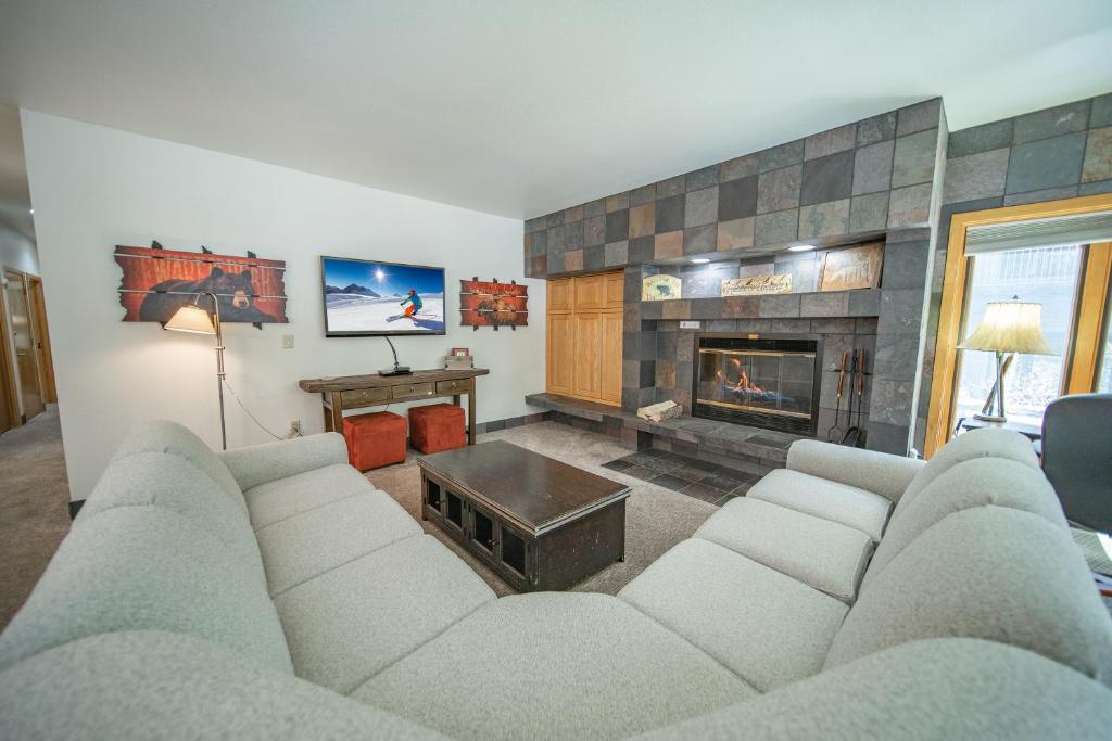 sala de estar con sofá y chimenea en Chateaux Dumont 2704, en Keystone