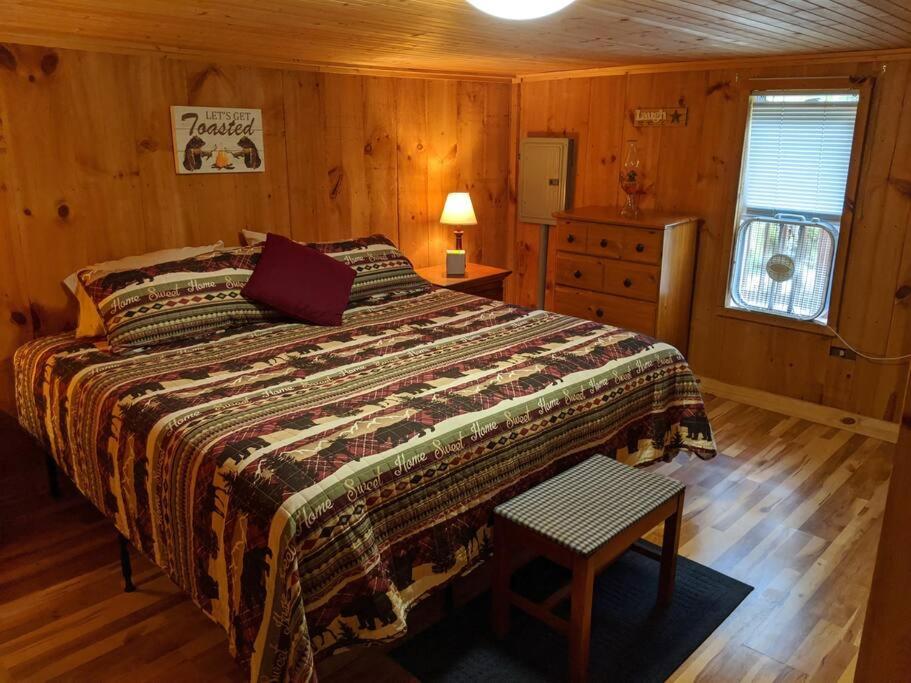 ein Schlafzimmer mit einem Bett in einem Holzzimmer in der Unterkunft Woodard Cabin in Cullowhee