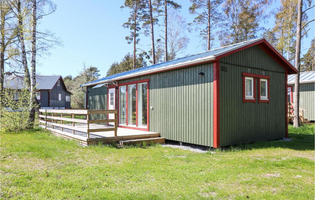 un bâtiment vert et rouge dans un champ dans l'établissement Amazing Home In Lttorp With Wifi, à Löttorp