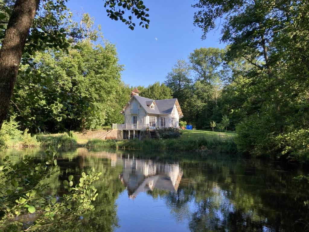 a white house sitting on the side of a river at Gîte Clairefontaine-en-Yvelines, 3 pièces, 5 personnes - FR-1-527-8 in Clairefontaine