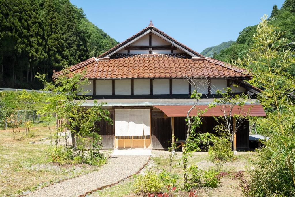 uma pequena casa com telhado de azulejo em 日貫一日　安田邸 em Ohnan-cho